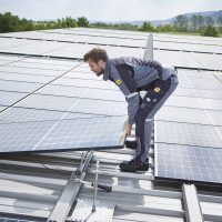 Elektroniker hebt Photovoltaik-Modul an