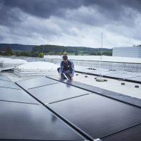 E-Handwerker kontrolliert PV-Anlage auf dem Dach